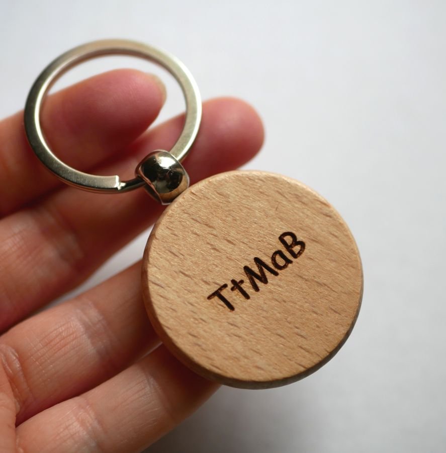 Rund nøkkelring i tre som kan personaliseres med gravering.